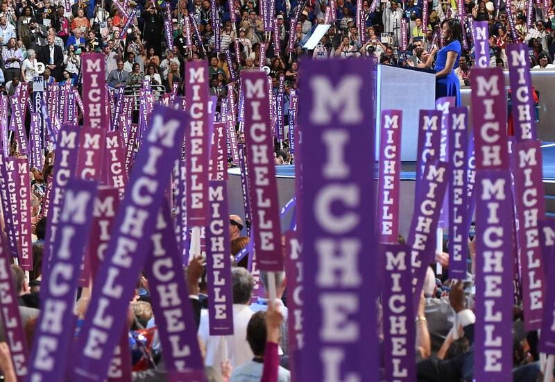 Delegates hold up signs supporting US first lady Michelle Obama on the first day of the Democratic National Convention in Philadelphia. Robyn Beck  / AFP Photo