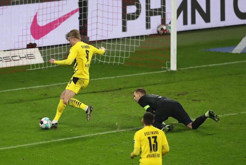 LEIPZIG, GERMANY - JANUARY 09: Erling Haaland of Borussia Dortmund scores their team's third goal past Peter Gulacsi of RB Leipzig during the Bundesliga match between RB Leipzig and Borussia Dortmund at Red Bull Arena on January 09, 2021 in Leipzig, Germany. Sporting stadiums around Germany remain under strict restrictions due to the Coronavirus Pandemic as Government social distancing laws prohibit fans inside venues resulting in games being played behind closed doors. (Photo by Maja Hitij/Getty Images)