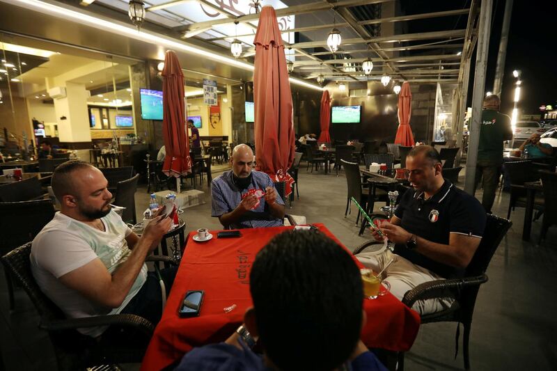People play cards at a cafe, amid fears of a rising number of coronavirus cases in Amman, Jordan. Reuters