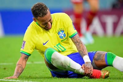 Brazil's Neymar grabs his ankle after an injury during the World Cup group G soccer match between Brazil and Serbia, at the the Lusail Stadium in Lusail, Qatar on Thursday, Nov.  24, 2022.  (Laurent Gillieron / Keystone via AP)
