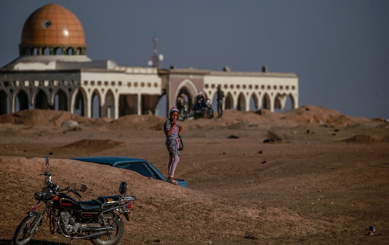 A Palestinian girl stands near destroyed buildings on the grounds of the airport.   