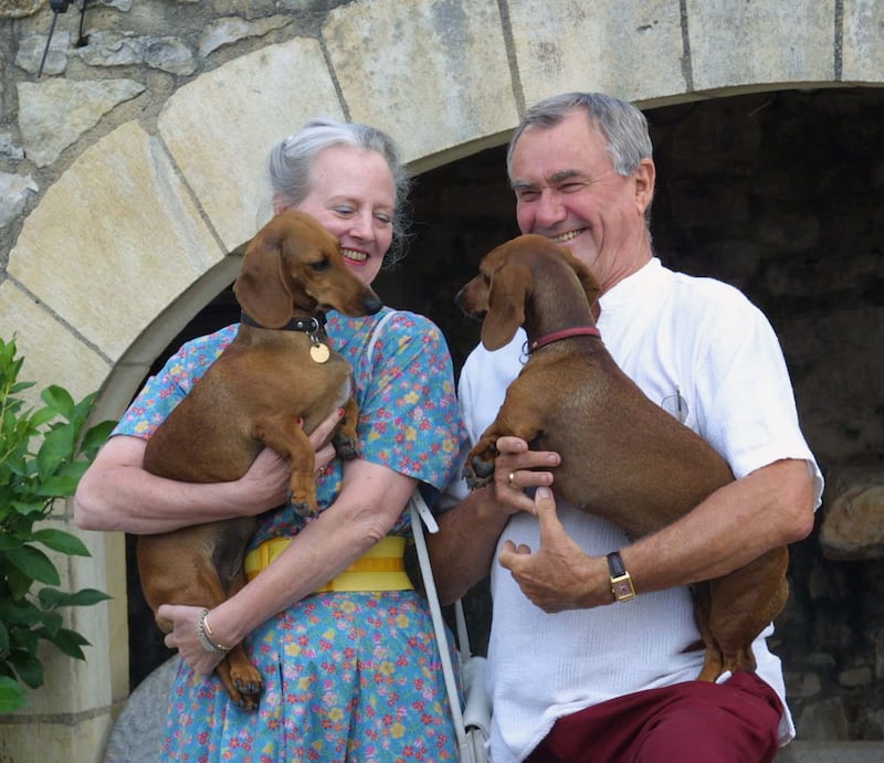 Queen Margrethe of Demark (L) and Prince Consort Henrik pose at their summer residence, the château de Caïx, 07 August 2001 with their dogs  Evita and Célimène. (Photo by ERIC CABANIS / AFP)