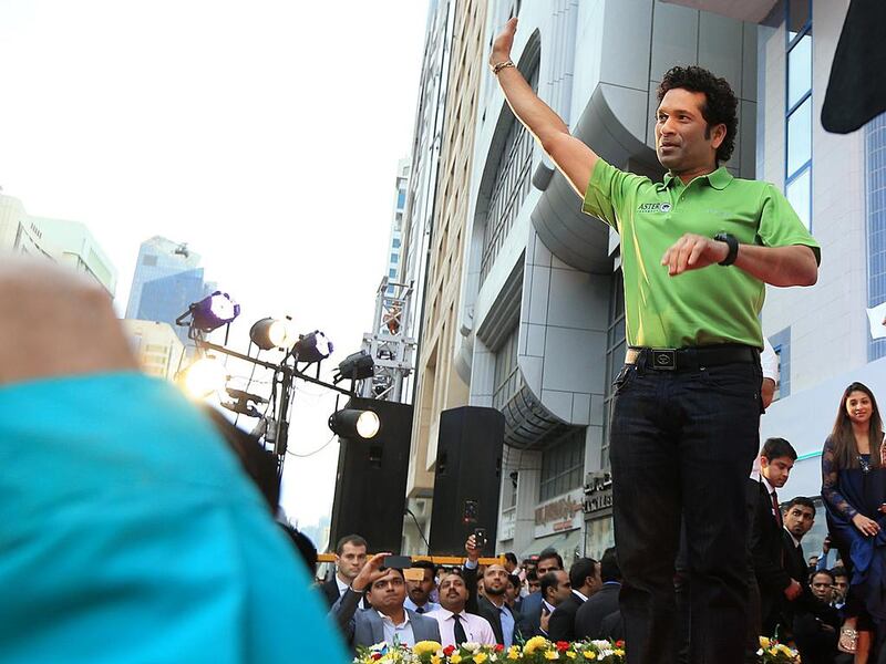 Former Indian cricketer Sachin Tendulkar waves to his fans before the inauguration of the 150th Aster Pharmacy, on Hamdan Street in Abu Dhabi. Ravindranath K / The National

