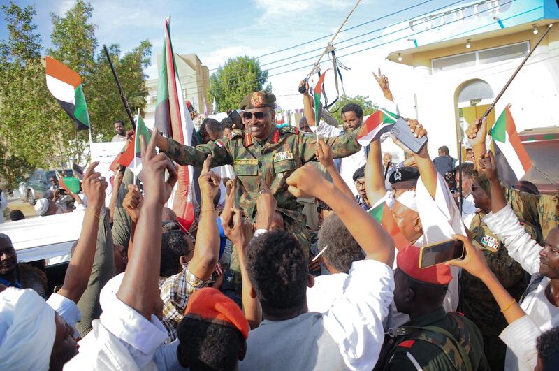People carry Othman Mohamed, a senior general loyal to Gen Al Burhan, on their shoulders in Port Sudan on April 20. AFP
