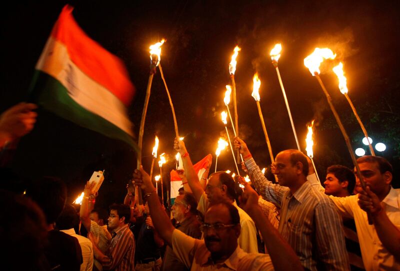 Supporters of veteran Indian social activist Anna Hazare hold torches and an Indian national flag during a protest rally against corruption in Kolkata August 18, 2011. India's beleaguered government caved in to popular fury over corruption on Wednesday after thousands protested across the country, granting permission for a self-styled Gandhian crusader to stage a 15-day hunger strike in public. Hazare was arrested on Tuesday, hours ahead of a planned fast to demand tougher laws against the graft that plagues Indian society from top to bottom. REUTERS/Rupak De Chowdhuri (INDIA - Tags: POLITICS CIVIL UNREST) *** Local Caption ***  DEL13_INDIA-PROTEST_0818_11.JPG