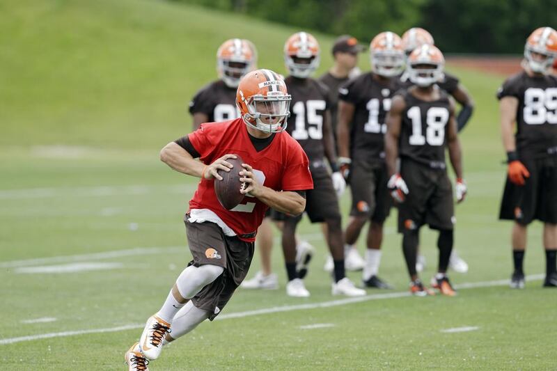 Cleveland Browns quarterback Johnny Manziel runs the ball under the watchful eye of his teammates at a minicamp practice in June. Mark Duncan / AP Photo

