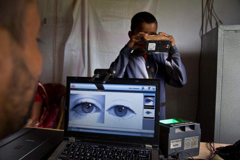 A National Register of Citizens (NRC) officer takes a photograph of the eyes of a boy at an NRC center on the eve of the release of the final NRC draft in Gauhati, India, Friday, Aug. 30, 2019. India plans to publish a controversial citizenship list that advocates say will help rectify decades of unchecked illegal immigration into the northeastern state of Assam from Bangladesh. Critics fear it will leave off millions of people, rendering them stateless. (AP Photo/Anupam Nath)