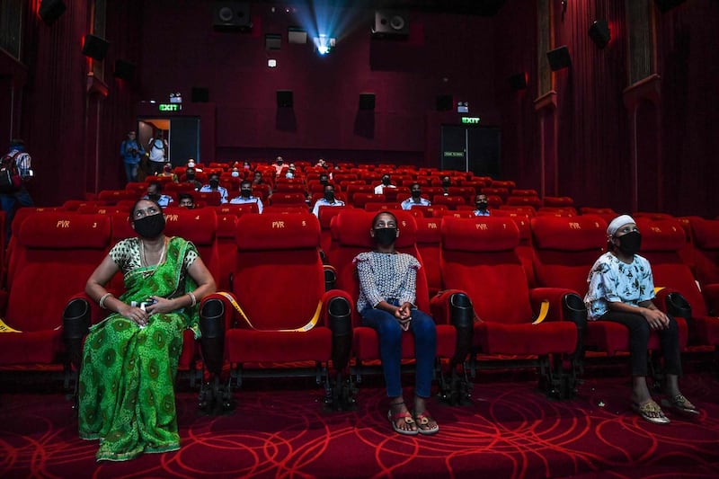 People invited as 'Covid-19 warriors' and their families to a special screening watch Bollywood movie 'Tanhaji' in a cinema in New Delhi on October 15, 2020, with some states still keeping theatres closed amid the Covid-19 coronavirus pandemic.  / AFP / Prakash SINGH
