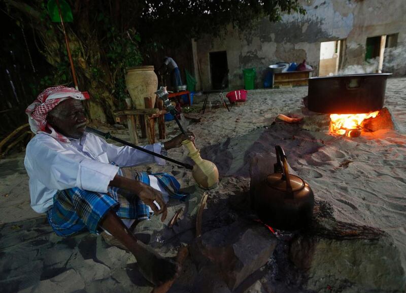 An Emirati man prepares traditional food.