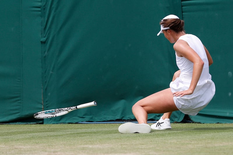 Poland's Iga Swiatek falls after playing a shot between her legs to Ons Jabeur.