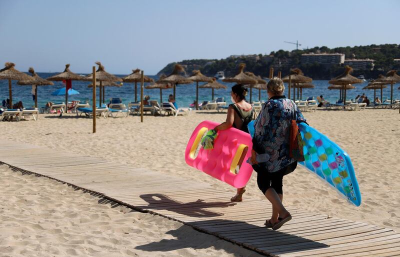 MALLORCA, SPAIN - JULY 30: People arrive at Magaluf beach on July 30, 2020 in Mallorca, Spain. The United Kingdom, whose citizens comprise the largest share of foreign tourists in Spain, added Mallorca and other Spanish islands to its advice against non-essential travel to the country, citing a rise in coronavirus cases. The change follows the UK's decision to reimpose a 14-day isolation period for travelers returning from Spain. (Photo by Clara Margais/Getty Images)