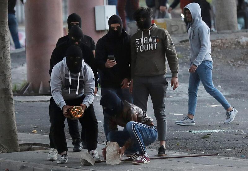 A supporter of the Shiite Hezbollah and Amal Movement groups holds firecrackers to fire it at the riot police. AP