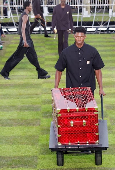 A model walks pushing a trolley of Louis Vuitton luggage. AFP