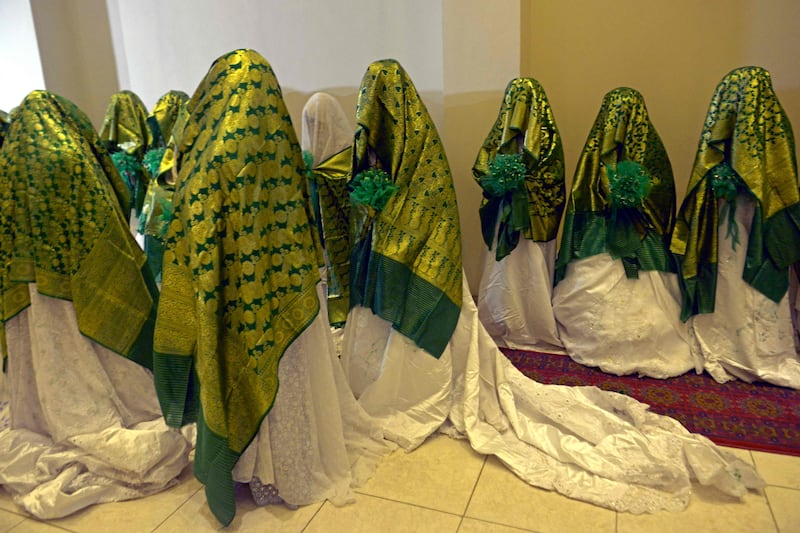 Brides wait for the start of a mass wedding in Kabul. Dozens of Afghan women, concealed in thick green shawls, were married off in an austere ceremony attended by hundreds of guests and gun-toting Taliban fighters. AFP
