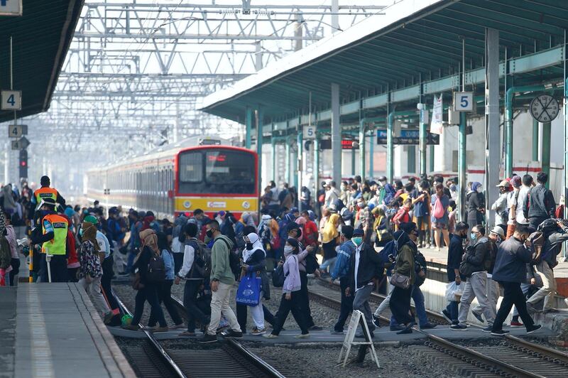 People wearing protective face masks make their way during rush hour at a train station in Jakarta, Indonesia, . Reuters