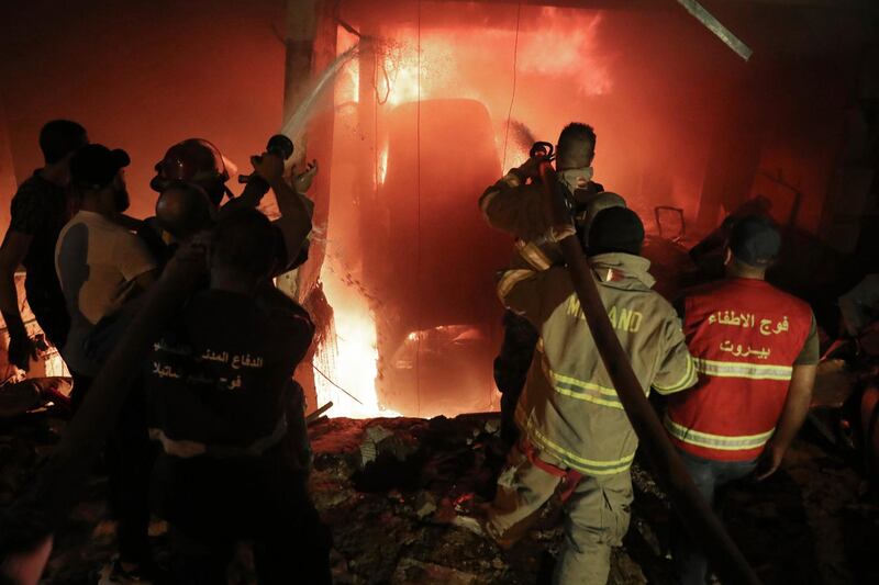 Firefighters extinguish a fire at a building after a diesel tank exploded. AP
