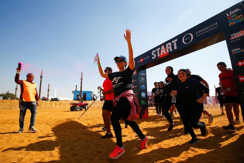 Competitors raise their arms in celebration as they cross the finish line, during Egypt's Tough Mudder challenge, at the O West district, in Giza. Reuters