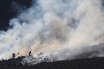 Firefighters work at fire on a moor above Carrwood, Britain, June 27, 2018. REUTERS/Phil Noble