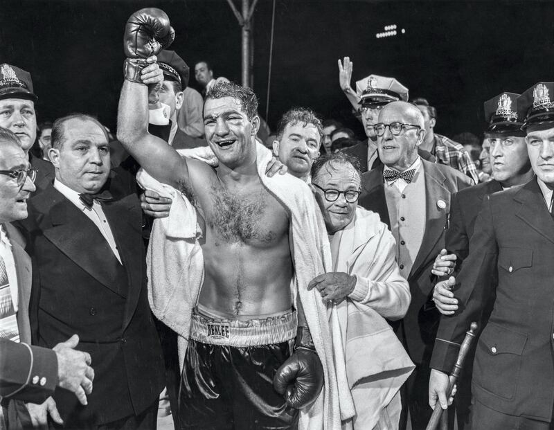 PHILADELPHIA, PA - SEPTEMBER 23:  The winner and new World Heavyweight Champion Rocky Marciano by virtue of a 13th round knockout poses for a portrait. Looking over Marciano's shoulder at right are Freddy Brown and Charles Goldman (with glases clinging to Rocky), on September 23, 1952 at Municipal Stadium in Philadelphia, Pennsylvania.  (Photo by The Stanley Weston Archive/Getty Images) 