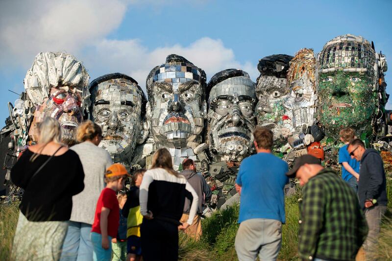 People look at artwork called Mount Recyclemore: The E7, which has been created out of e-waste, in the likeness of the G7 leaders and in the style of Mount Rushmore by British artist Joe Rush on Sandy Acres Beach in Cornwall. AP Photo