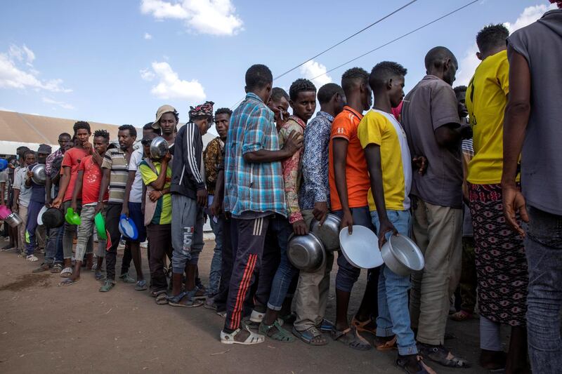 Tigrayan refugees wait in line to revive food from Muslim Aid at Hamdeyat Transition Center near the Sudan-Ethiopia border, eastern Sudan, Wednesday, March 24, 2021. (AP Photo/Nariman El-Mofty)