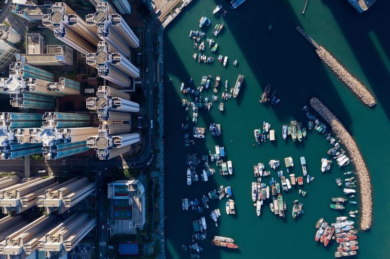 Boats moored at a typhoon shelter next to residential buildings in Hong Kong.