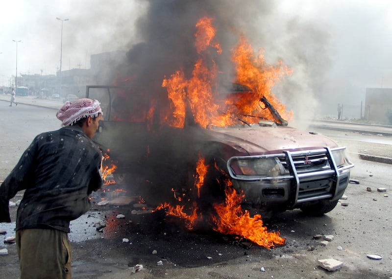 March 31, 2004: A car burns in the aftermath of an insurgent attack on Fallujah, in which four Blackwater private security contractors were killed and their mutilated, burnt bodies were left hanging from a bridge. Reuters 