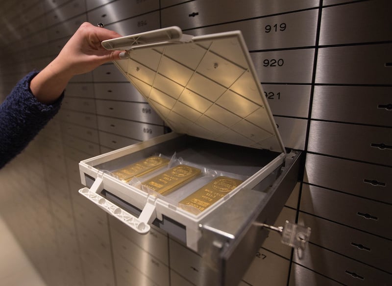 One ounce 24 carat gold bars are placed into a safety deposit box at the Sharps Pixley Ltd gold showroom, in this arranged photograph in London, U.K., on Monday, Jan. 11, 2016. The metal posted the biggest weekly gain since August last week as escalating concerns about China's outlook, a rout in equities and increased geopolitical tensions in the Middle East and North Korea stoked investors' aversion to risk. Photographer: Simon Dawson/Bloomberg