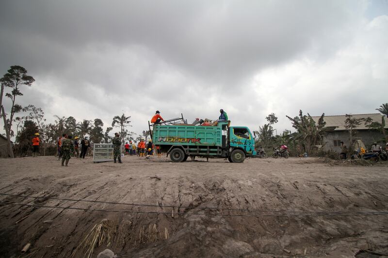 Villagers load their belongings on to a truck as they leave their houses. EPA 