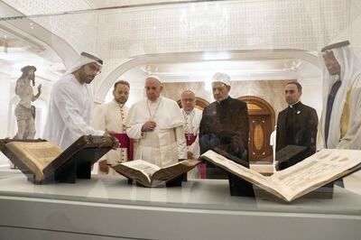 ABU DHABI, UNITED ARAB EMIRATES - February 4, 2019: Day two of the UAE papal visit -  His Holiness Pope Francis, Head of the Catholic Church (centre L), and His Eminence Dr Ahmad Al Tayyeb, Grand Imam of the Al Azhar Al Sharif (centre R), look at versions of the Quran, Bible and Torah on loan from the Louvre Abu Dhabi. Seen with HE Mohamed Khalifa Al Mubarak, Chairman of the Department of Culture and Tourism and Abu Dhabi Executive Council Member (L), and HH Sheikh Mohamed bin Zayed Al Nahyan, Crown Prince of Abu Dhabi and Deputy Supreme Commander of the UAE Armed Forces (R), during a dinner reception at Al Mushrif Palace. 
( Ryan Carter / Ministry of Presidential Affairs )
---