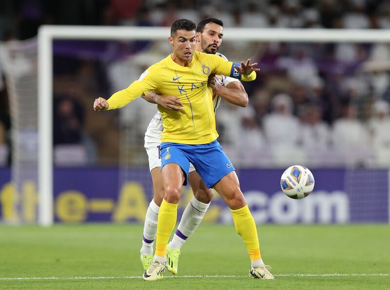 Al Nassr's Cristiano Ronaldo battles with Al Ain's Khalid Al Hashemi.