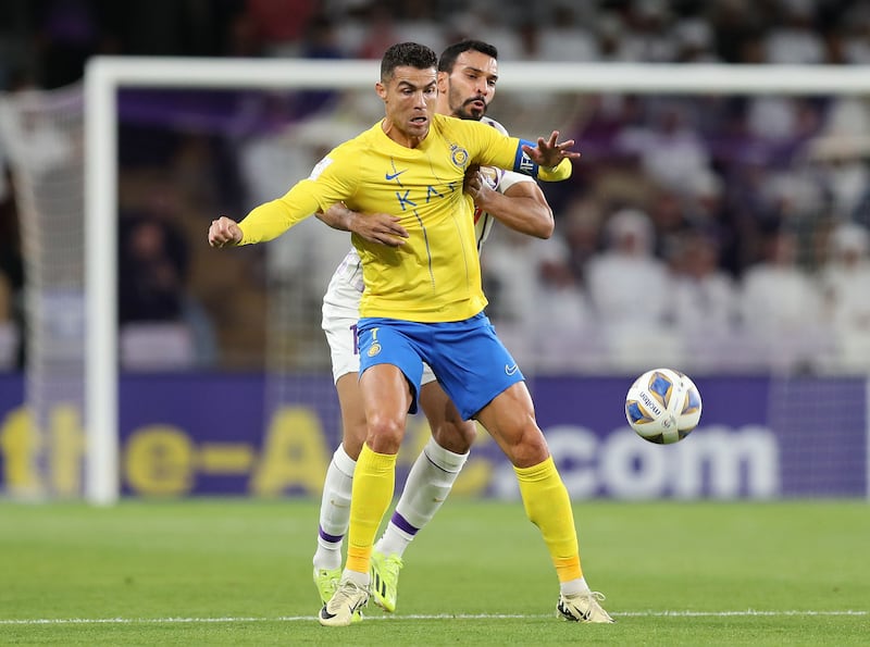 Al Nassr's Cristiano Ronaldo battles with Al Ain's Khalid Al Hashemi.