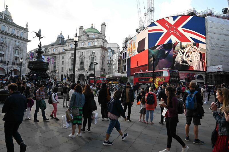 Members of the public walk through Piccadilly Circus before the platinum jubilee celebrations for Queen Elizabeth. AFP
