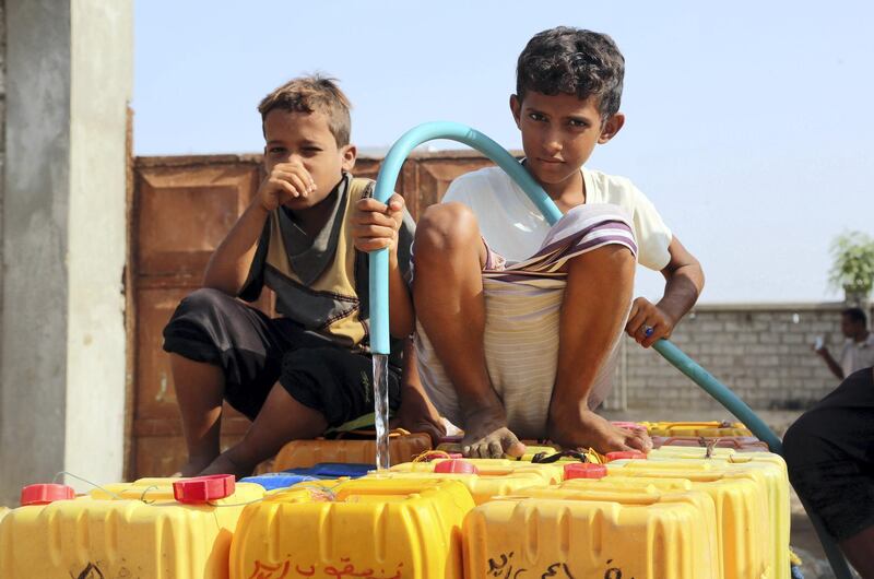 Yemeni children fill empty jerrycans with water from a donated source amid ongoing widespread disruption of water supplies in an impoverished coastal village on the outskirts of the Yemeni port city of Hodeidah, on October 18, 2016. / AFP PHOTO / STRINGER
