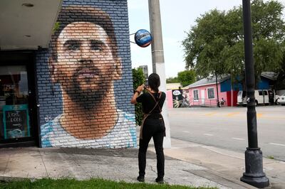 A football fan takes a photograph of a mural of Lionel Messi outside of the Fiorito restaurant in Miami.  AP Photo