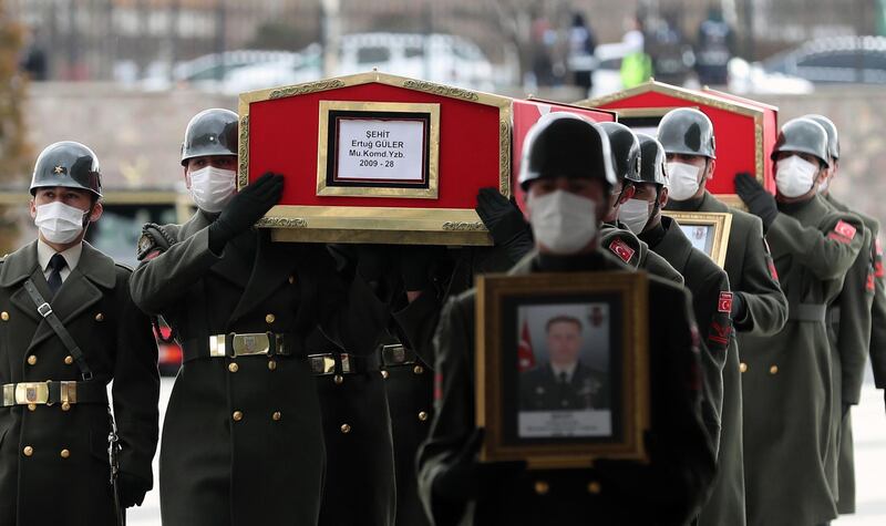 The coffin and image of Turkish Lt. Ertug Guler are carried during the funeral of three Turkish military personnel killed in action at Ankara's Ahmet Hamdi Akseki Mosque in Ankara on February 12, 2021.  The three soldiers Lt. Burak Coskun, Lt. Ertug Guler and Sgt. First Class Harun Turhan were killed during clashes with Kurdish militants in northern Iraq's Gara region as part of the Eagle Claw 2 operation by the Turkish military against the outlawed Kurdistan Workers' Party (PKK).  / AFP / Adem ALTAN
