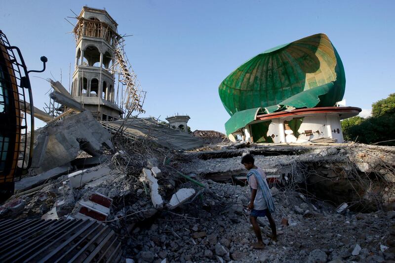 A resident inspects a mosque damaged by an earthquake in North Lombok, Indonesia. AP Photo
