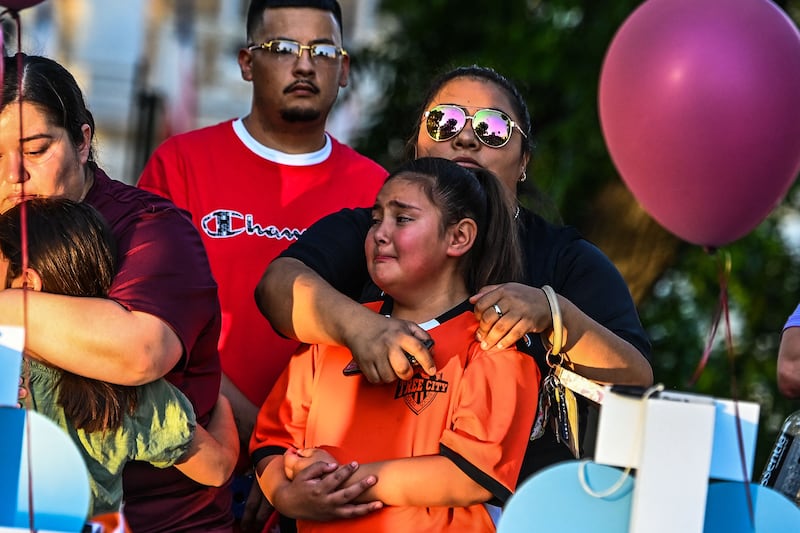 A football teammate of shooting victim Tess Mata cries, supported by her mother.  AFP
