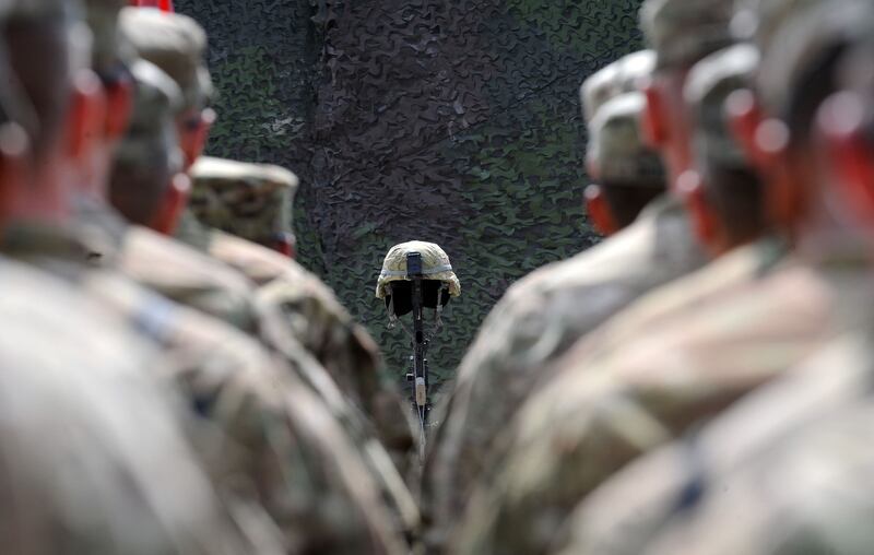 US soldiers stand at attention as they pay their respects to a fallen soldier in eastern Afghanistan on July 10, 2011. AFP