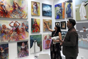 Visitors looking at the art works which are on display at World Art Dubai 2019, held at Dubai World Trade Centre. Pawan Singh / The National 