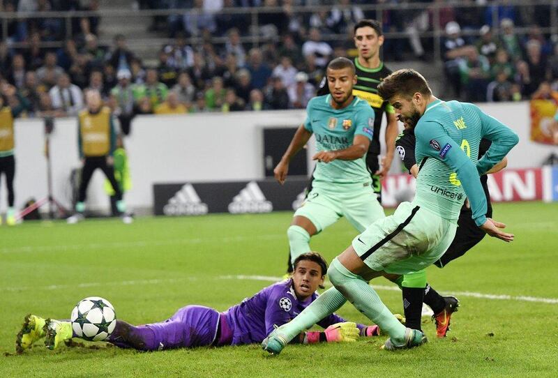 Barcelona’s Gerard Pique, right, scores his side’s second goal during the Champions League match against Borussia Monchengladbach. Martin Meissner / AP Photo