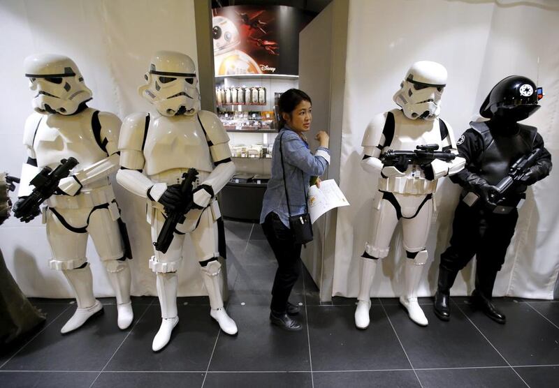 A store staff walks past other staffs dressed up as Stormtrooper and Death Star Gunner right. Toru Hanai / Reuters