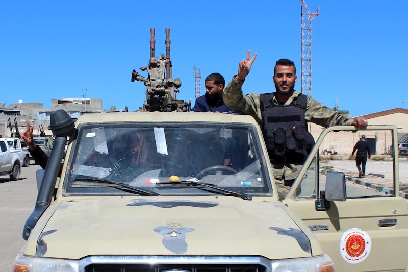 epa07492507 Militants, reportedly from the Misrata militia, flash the victory sign as they gather before heading to the frontline to join forces defending the capital, in Tripoli, Libya, 08 April 2019. Commander of the Libyan National Army (LNA) Khalifa Haftar on 04 April ordered Libyan forces loyal to him to take the capital Tripoli, held by a UN-backed unity government, sparking fears of further escalation in the country. The UN said thousands had fled the fighting in Tripoli, while ministry of health reported 25 people, including civilians, were killed in the fighting.  EPA/STRINGER   ALTERNATIVE CROP