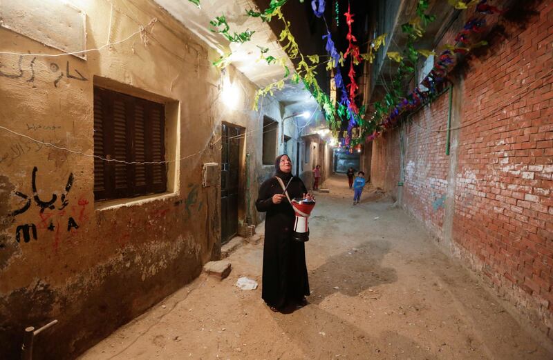 Hajja Dalal, a 46-year-old Mesaharati, beats a drum to wake up Muslims to have the predawn meal before they start their long-day fast during  Ramadan, at Maadi neighbourhood in Cairo, Egypt. Reuters