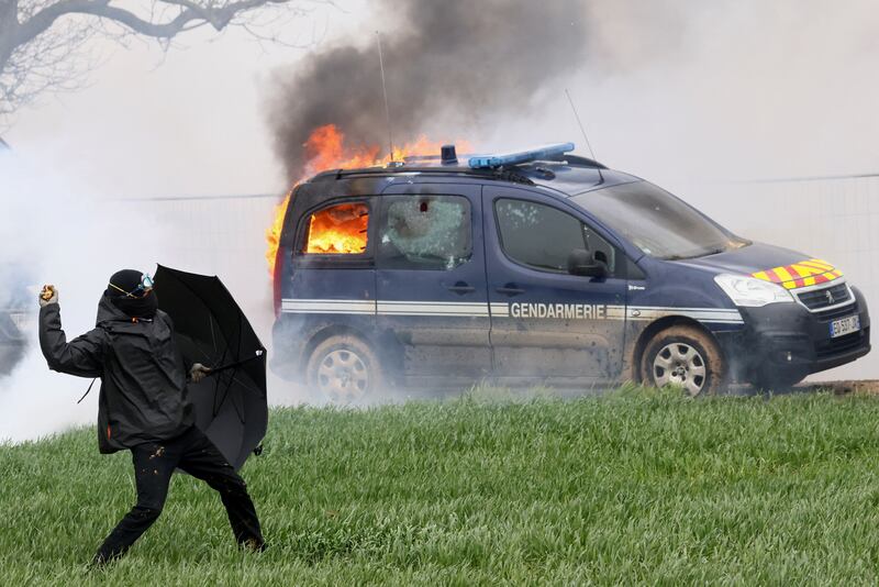 A police car burns during a protest against new reservoirs in Sainte-Soline, France. Reuters