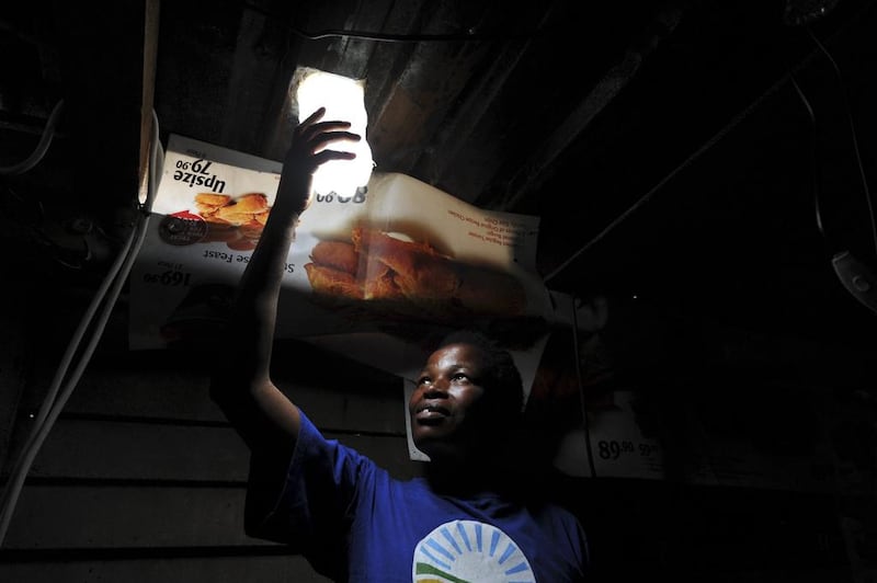 Mavis Mabaso showing her new bottle light in Johannesburg, South Africa. The “Litre of Light” project puts plastic bottles filled with water in shack roofs, providing light to shacks with no electricity during the day. Bongiwe Gumede / Foto24 / Gallo Images / Getty Images