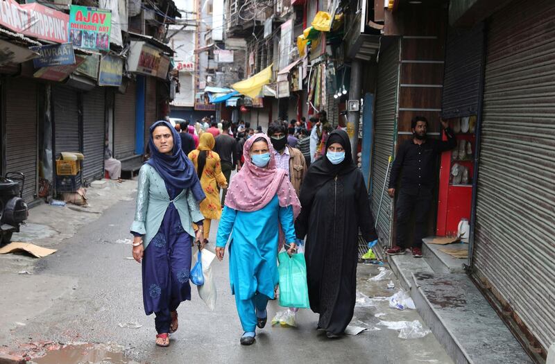 epa08482217 People walk along a street as markets open for the first time since the outbreak of coronavirus in Srinagar, Kashmir, India, 13 June 2020. The regional government ha allowed businesses to open for the first time since restrictions were imposed to reduce the spread of coronavirus and COVID-19.  EPA/FAROOQ KHAN