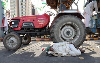 epa07064091 An Indian farmer from the Bhartiya Kisan Union sleeps near a tractor after he was stopped at the Delhi Gazipur Border during their march to New Delhi, India, 02 October 2018. Around 30 thousand farmers protested on the border between the Indian states of Delhi and Uttar Pradesh to demand loan waivers and clashed with police after being denied entry into the Indian capital.  EPA/RAJAT GUPTA