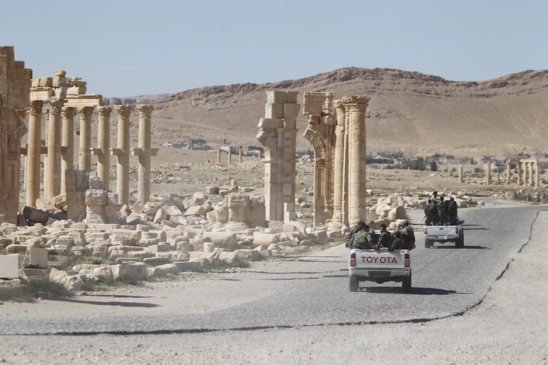 FILE PHOTO -  Syrian army soldiers drive past the Arch of Triumph in the historic city of Palmyra, in Homs Governorate, Syria April 1, 2016. REUTERS/Omar Sanadiki/File Photo