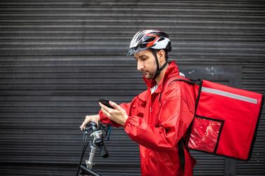 Male Bicycle delivery commuter with road bicycle in the city, using mobile phone to find customer location